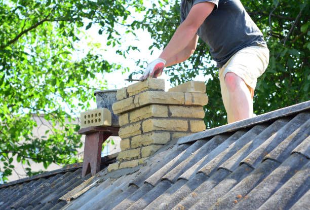 Mason reconstructing a brick chimney stack on a South Pasadena roof