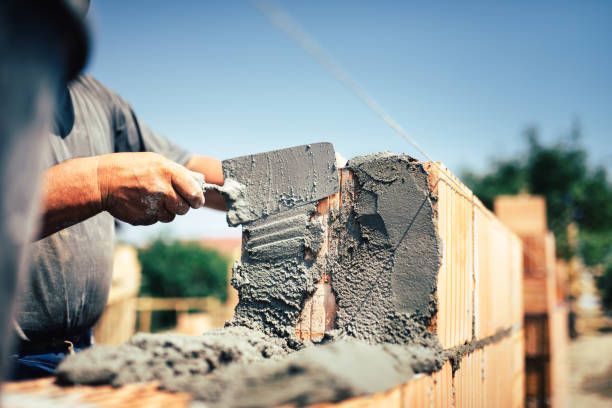 Bricklayer building a garden wall course by course