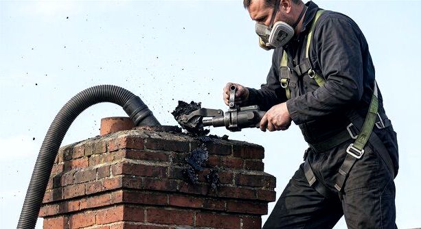 Technician extracting creosote during a flue relining job