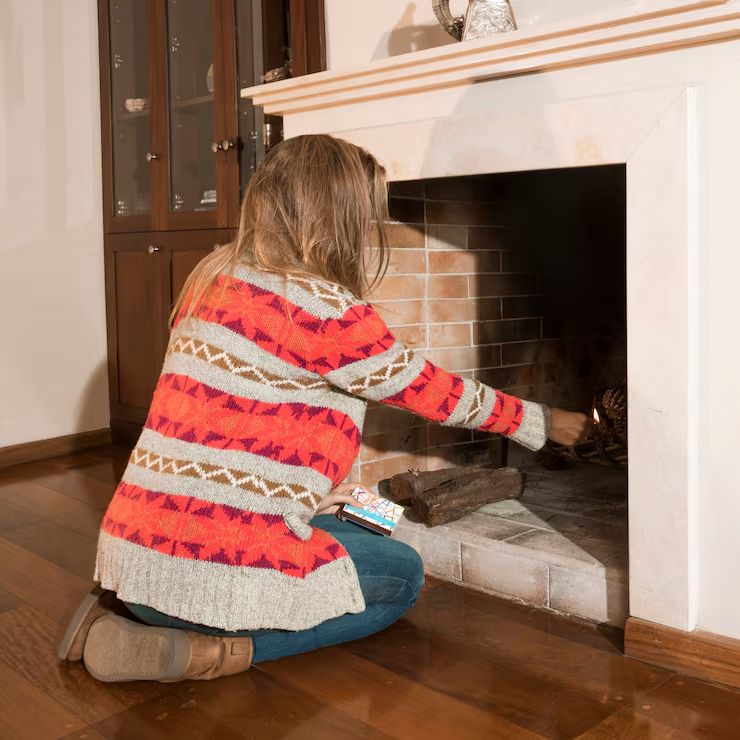 Homeowner lighting the first fire of the season in a clean fireplace